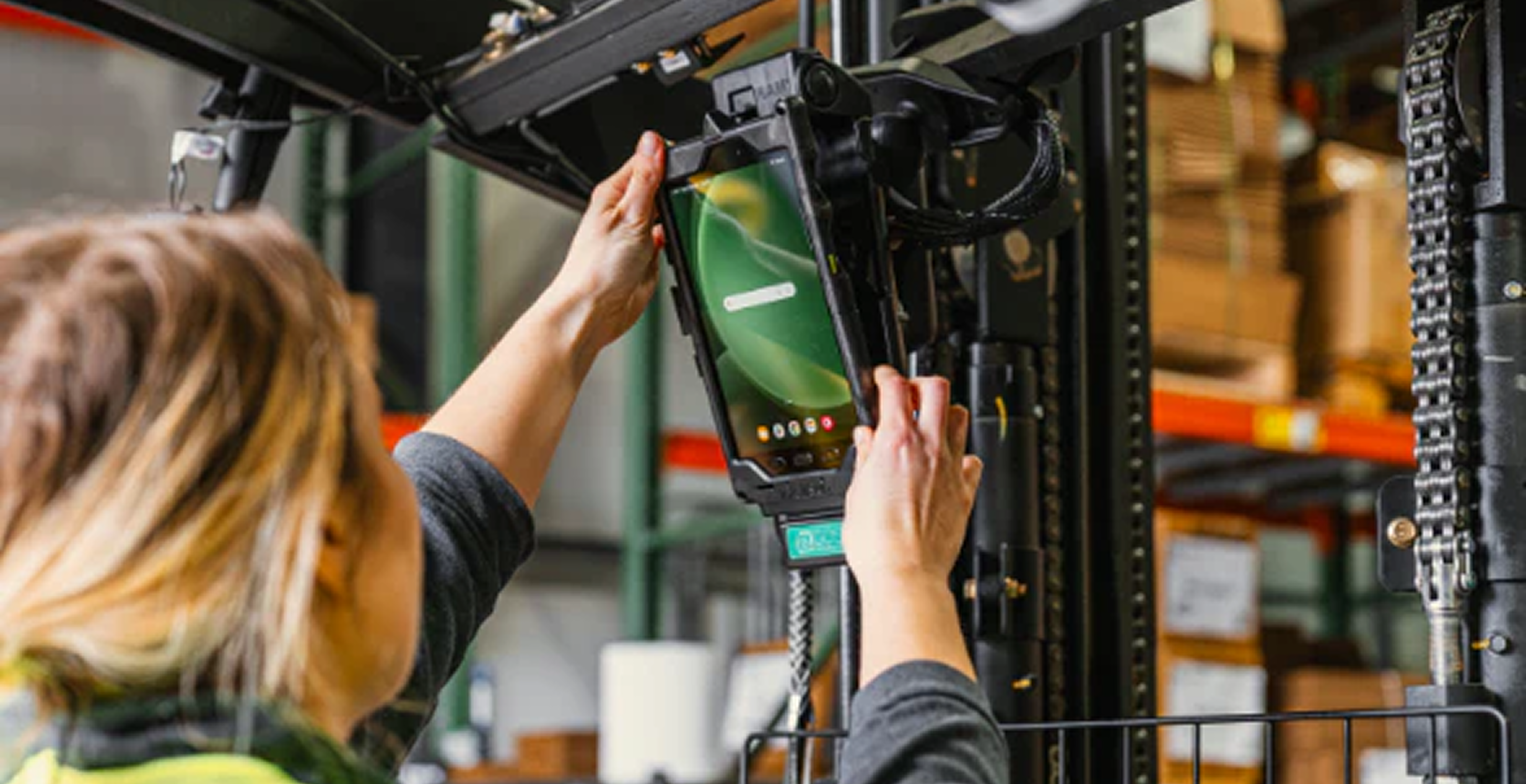 Modern warehouse with forklift operators managing boxed inventory for endpoint device rollout.