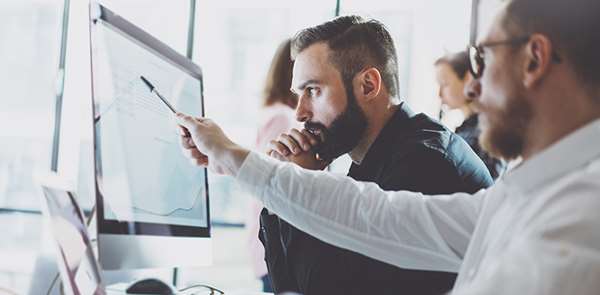 Fractional CISO reviewing security strategy on a monitor with an enterprise IT team