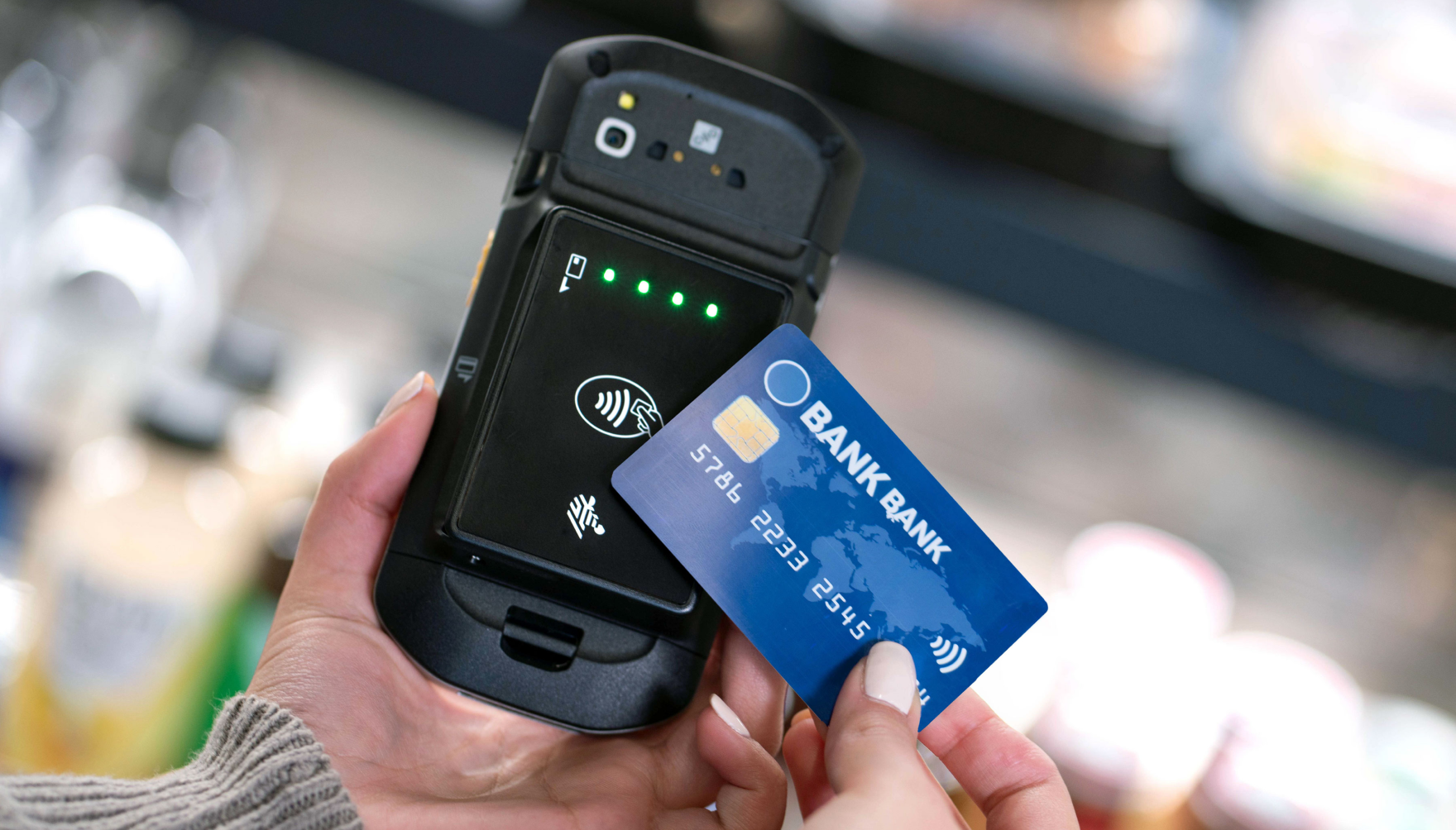 Customer using contactless payment with Zebra PD20 card reader in a retail environment.