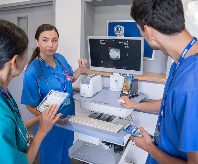 Healthcare worker using a clinical tablet at a nursing station managed by TRG