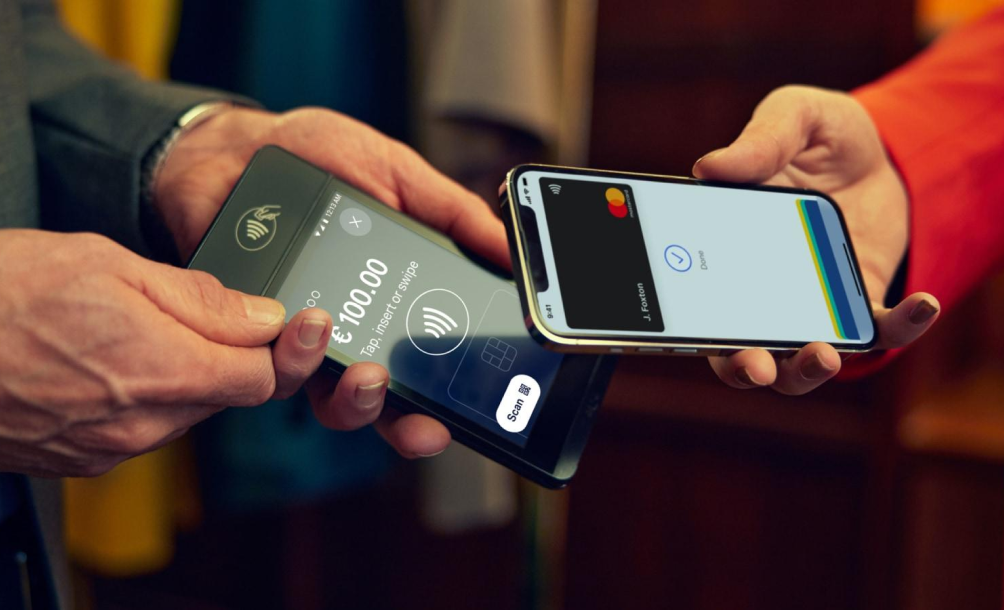 Smartphone displaying Mastercard payment beside a mobile point-of-sale terminal