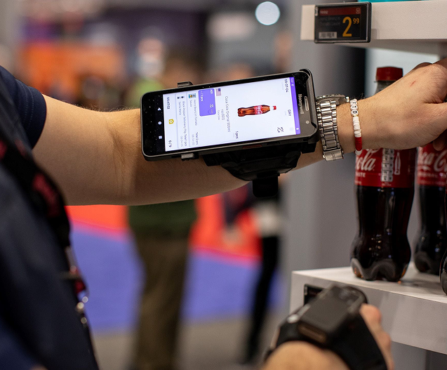 Employé(e) de magasin utilisant un scanneur d'inventaire portable géré par TRG