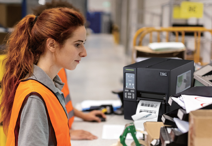 Operator working with a TSC industrial RFID label printer on the production floor