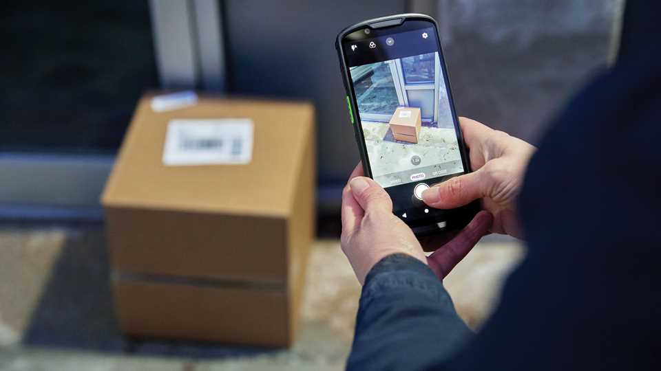 Driver scanning a parcel barcode with a TRG-managed smartphone