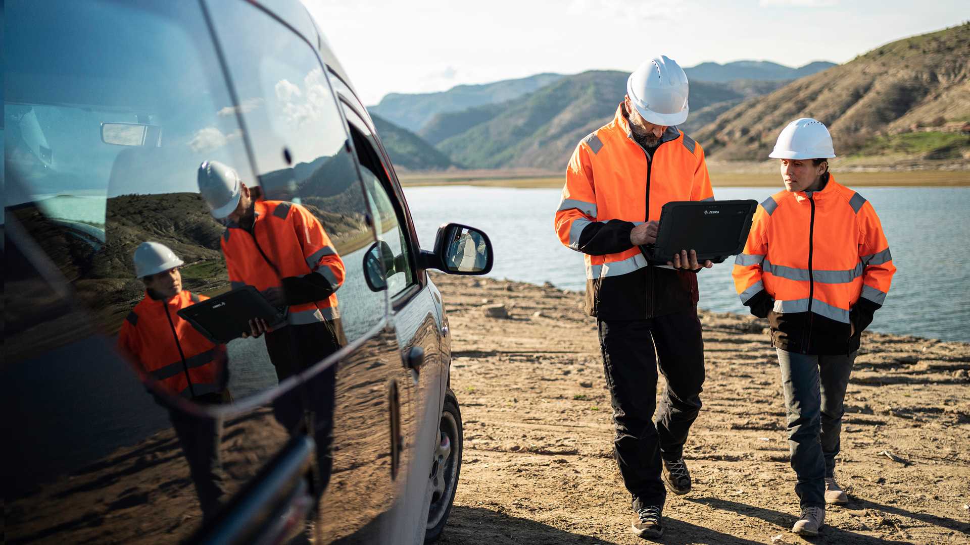 Field service technicians working from a service van at a lakeside jobsite