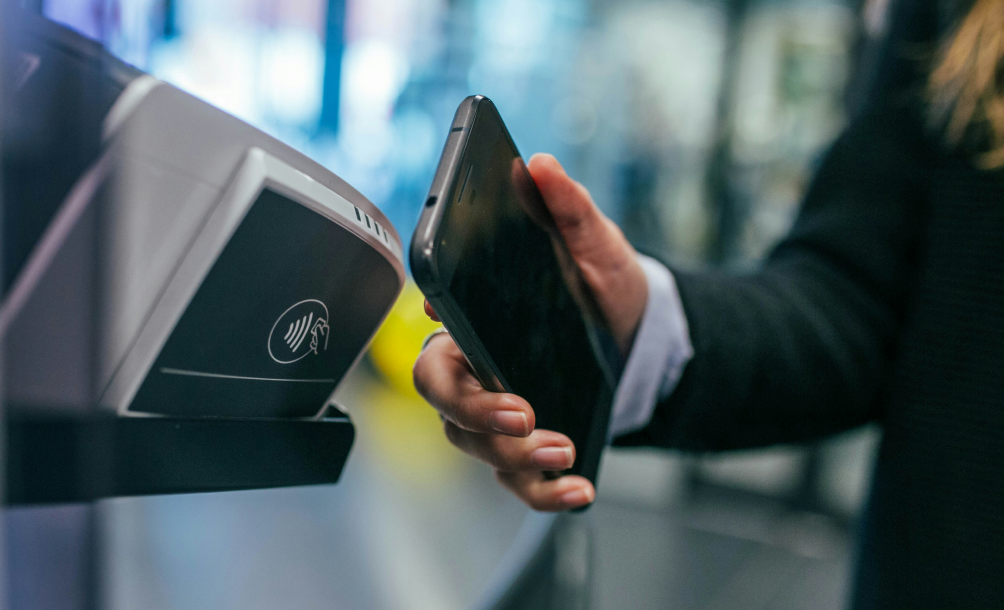 Smartphone displaying Mastercard payment beside a mobile point-of-sale terminal